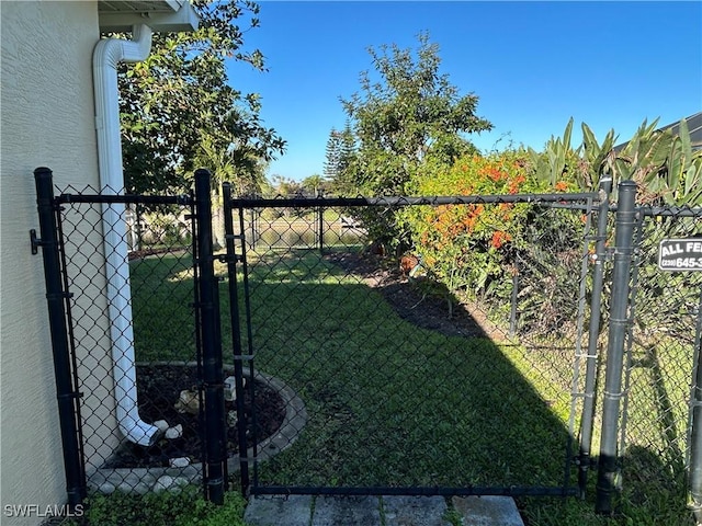 view of gate with a lawn and fence