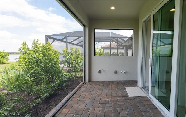 view of patio featuring glass enclosure