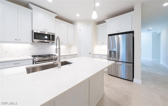 kitchen with pendant lighting, stainless steel appliances, backsplash, and white cabinets