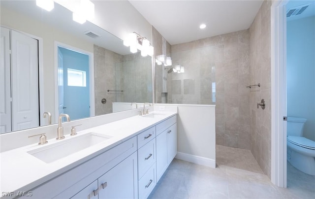 full bathroom featuring toilet, walk in shower, and a sink