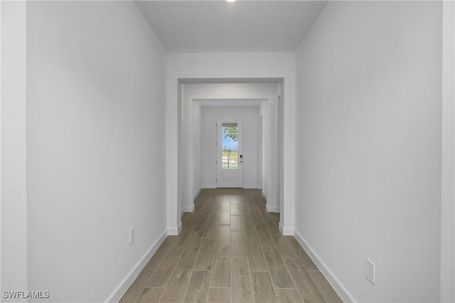 hallway with baseboards and light wood-style floors