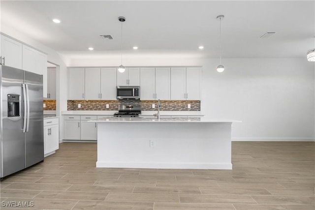 kitchen featuring visible vents, appliances with stainless steel finishes, light countertops, and decorative backsplash