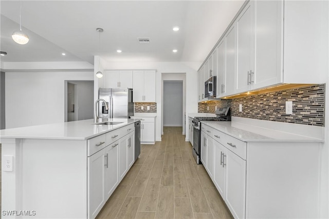 kitchen featuring stainless steel appliances, light wood-type flooring, a sink, and light countertops