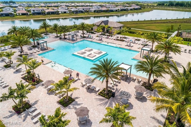 community pool with a water view, a residential view, and a patio