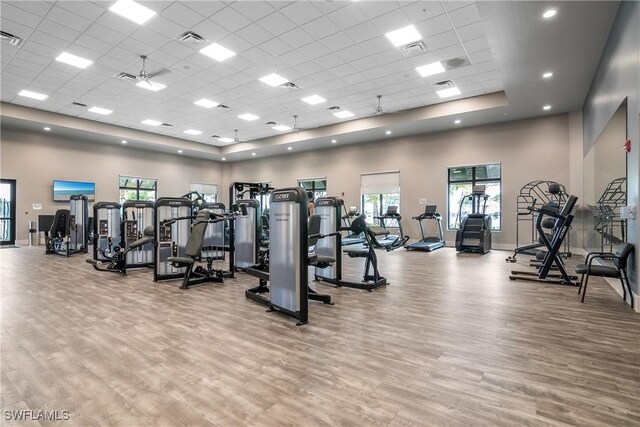 gym with a high ceiling, wood finished floors, and a wealth of natural light