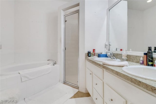 full bathroom featuring double vanity, a stall shower, a garden tub, and a sink