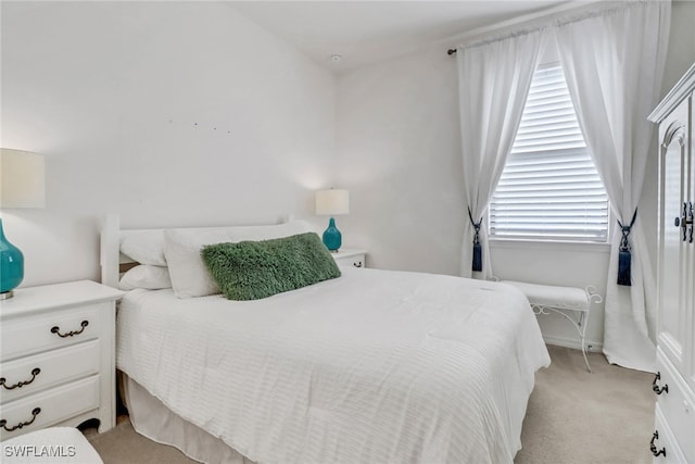 bedroom featuring light carpet and baseboards