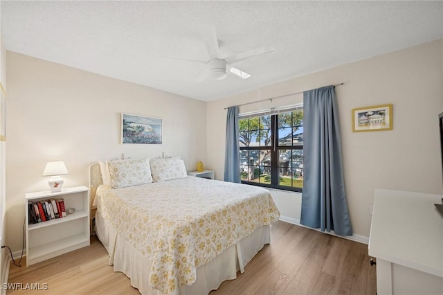 bedroom with a textured ceiling, ceiling fan, light wood-type flooring, and baseboards