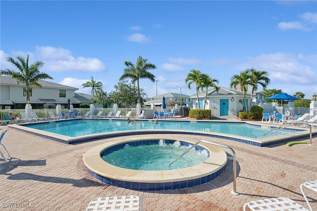 community pool featuring fence, a community hot tub, and a patio