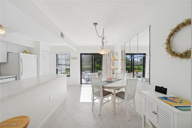 dining room with a textured ceiling, ceiling fan, light tile patterned floors, and visible vents