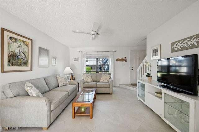 living area featuring a ceiling fan, a textured ceiling, and light tile patterned flooring