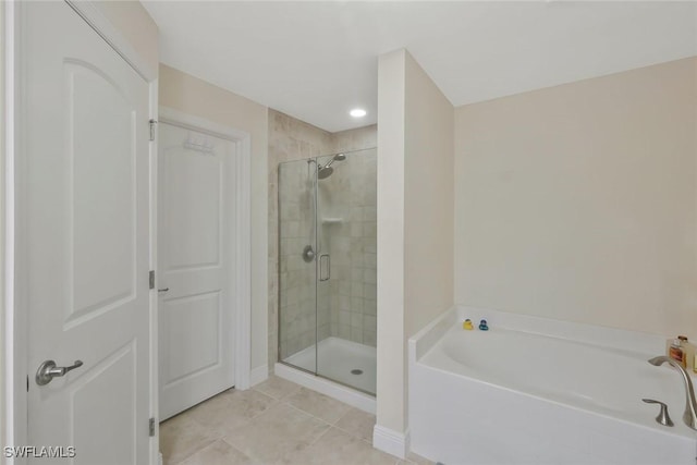 bathroom with a stall shower, tile patterned floors, and a bath