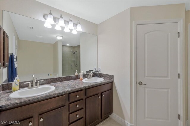 full bathroom featuring double vanity, visible vents, a sink, and tiled shower