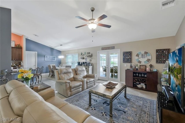 living room featuring french doors, light tile patterned floors, visible vents, ceiling fan, and vaulted ceiling