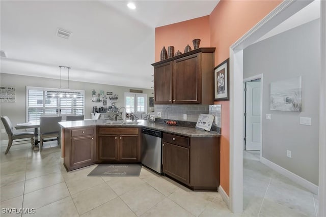 kitchen with dark countertops, backsplash, a peninsula, stainless steel dishwasher, and a sink