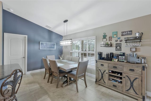 dining space featuring lofted ceiling, visible vents, baseboards, and light tile patterned flooring