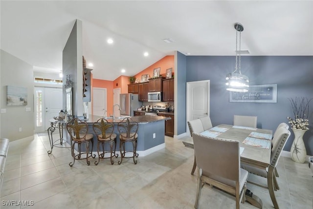 dining space featuring lofted ceiling, visible vents, baseboards, and light tile patterned flooring