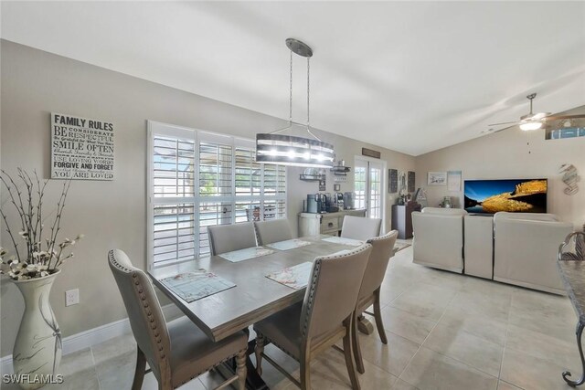 dining room with light tile patterned floors, ceiling fan, baseboards, and vaulted ceiling