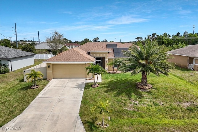 mediterranean / spanish-style house featuring solar panels, concrete driveway, a front yard, and an attached garage