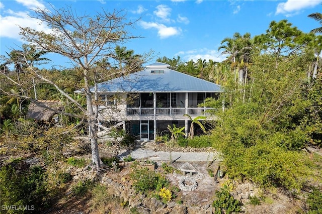 rear view of property featuring a sunroom and metal roof