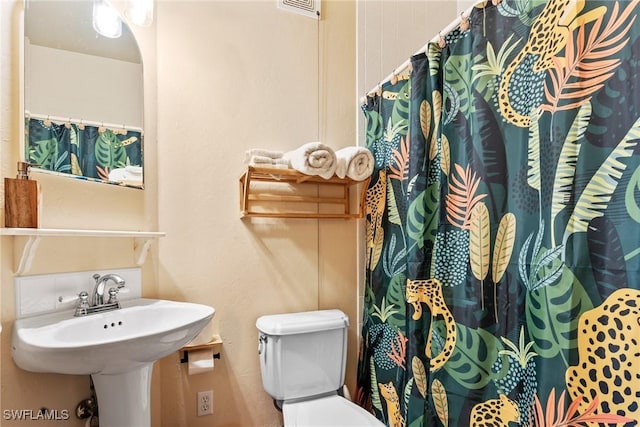 bathroom featuring visible vents, toilet, a shower with shower curtain, and a sink