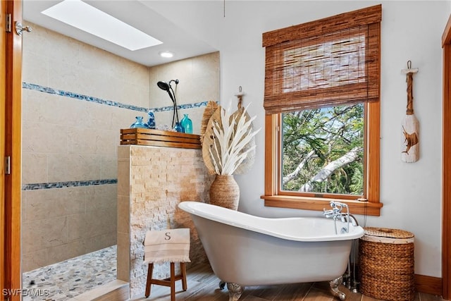 full bathroom featuring a freestanding bath, walk in shower, and a skylight