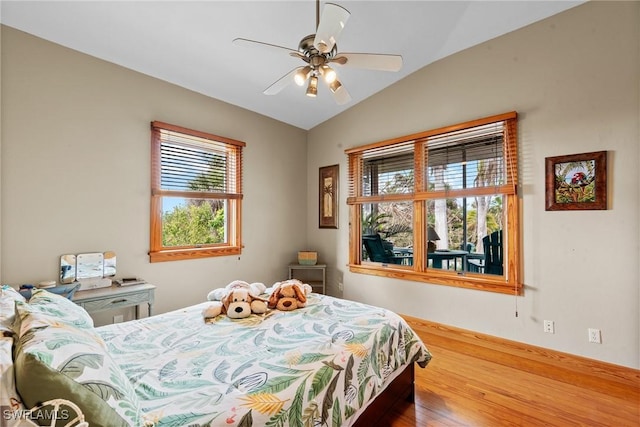 bedroom with a ceiling fan, lofted ceiling, and wood finished floors