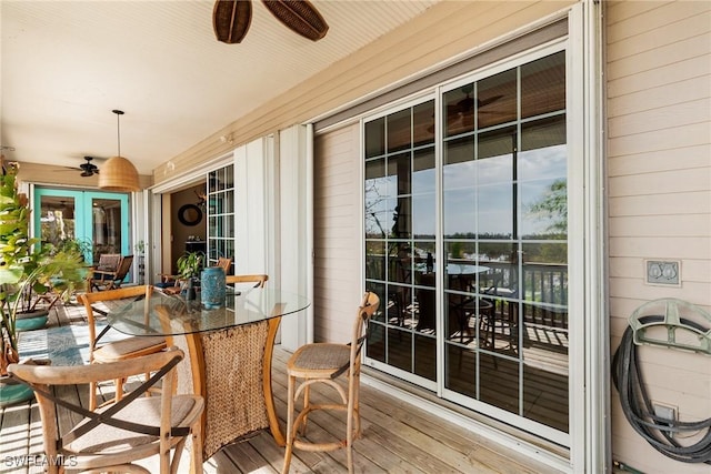 exterior space with french doors, outdoor dining area, a ceiling fan, and a sunroom