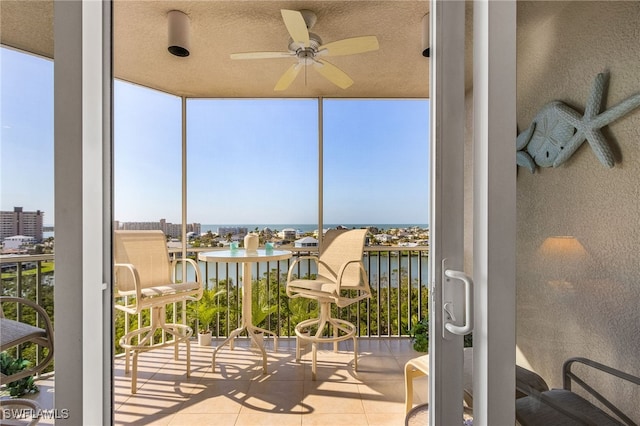 balcony with a water view and ceiling fan