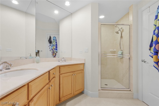 bathroom with double vanity, tile patterned floors, a sink, and a shower stall