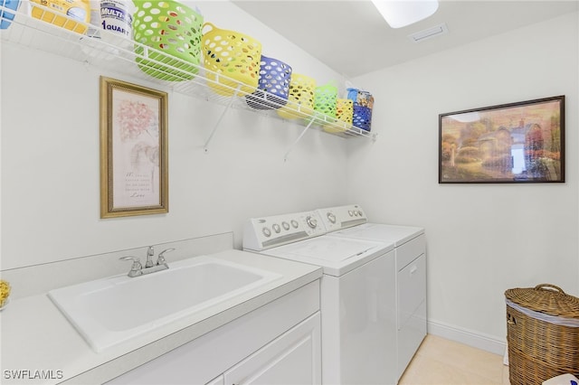 washroom featuring laundry area, light tile patterned floors, baseboards, washer and clothes dryer, and a sink