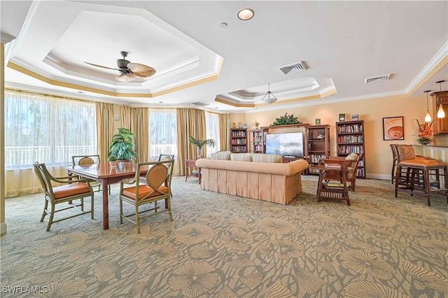 bedroom with baseboards, visible vents, a raised ceiling, ornamental molding, and carpet floors