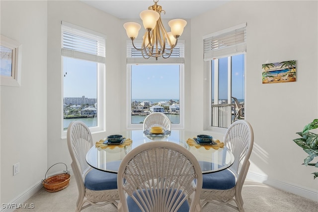 dining area with carpet, baseboards, and an inviting chandelier