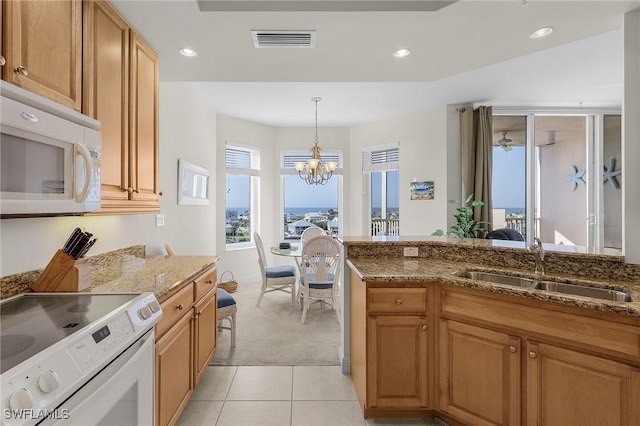 kitchen featuring stone countertops, recessed lighting, white appliances, a sink, and visible vents