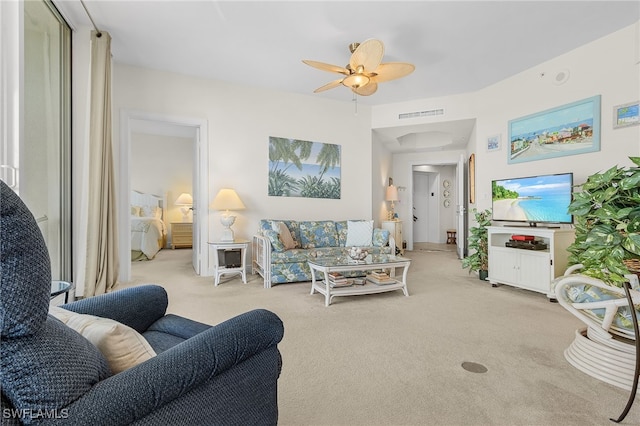 living area featuring visible vents, carpet, and a ceiling fan