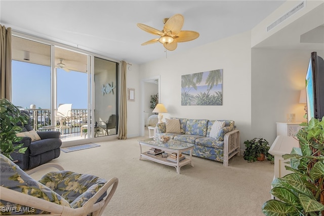 carpeted living room featuring floor to ceiling windows, visible vents, and a ceiling fan