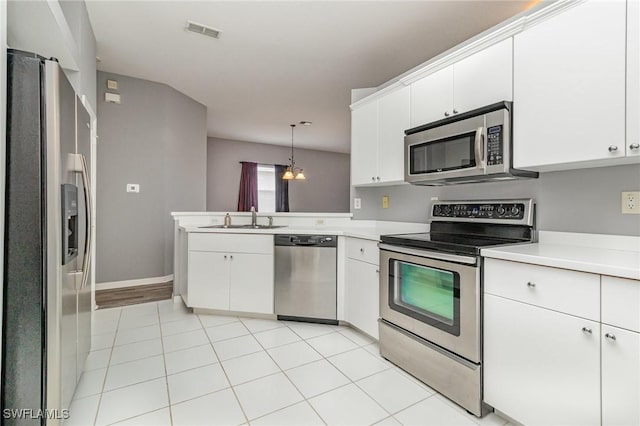 kitchen with stainless steel appliances, a peninsula, a sink, visible vents, and light countertops