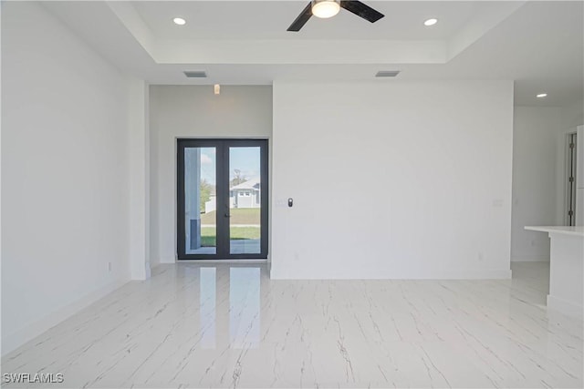 empty room featuring french doors, a tray ceiling, visible vents, and recessed lighting