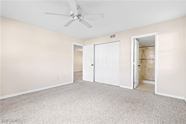 unfurnished bedroom featuring a closet, carpet flooring, ensuite bath, and baseboards