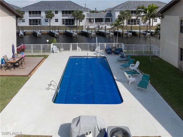 pool with a patio, a water view, fence, a yard, and a residential view