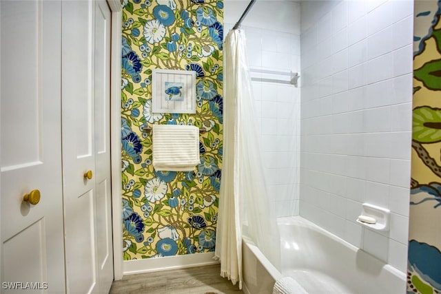 full bathroom with shower / tub combo, wood finished floors, baseboards, and wallpapered walls