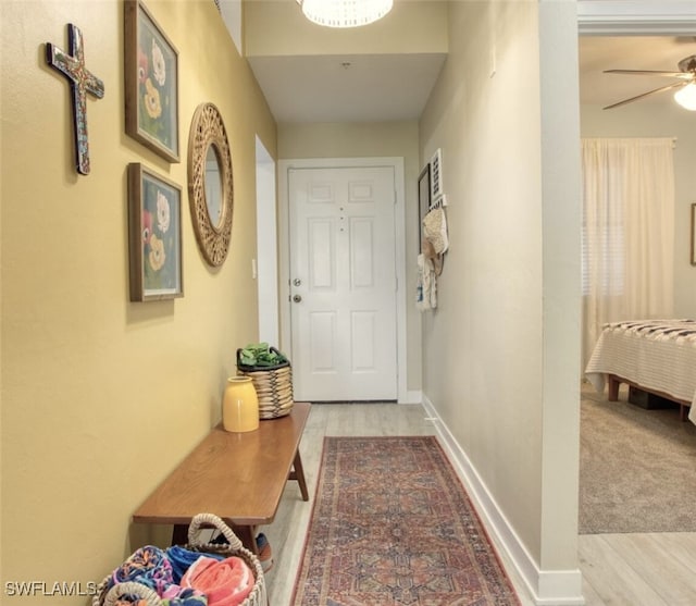 entryway featuring ceiling fan, wood finished floors, and baseboards