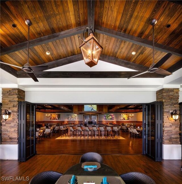 interior space with vaulted ceiling with beams, wood ceiling, ceiling fan, and wood finished floors