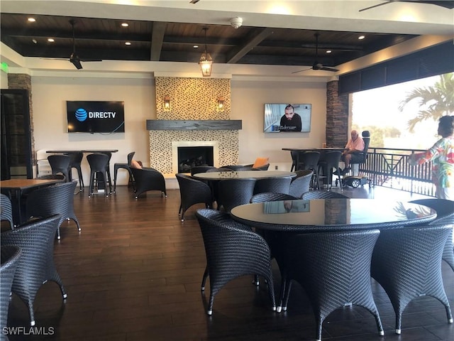 interior space featuring a tile fireplace, hardwood / wood-style flooring, ceiling fan, beam ceiling, and recessed lighting