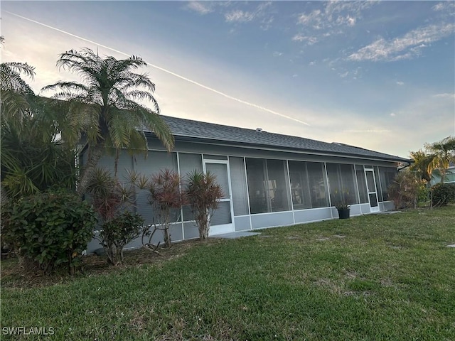 back of house with a yard and a sunroom