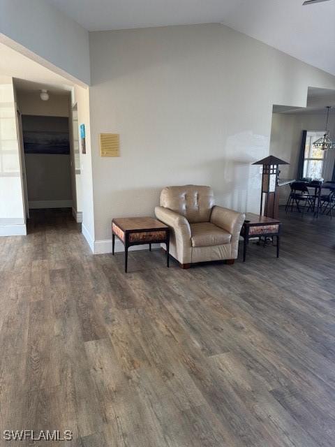 living room with lofted ceiling, wood finished floors, and baseboards