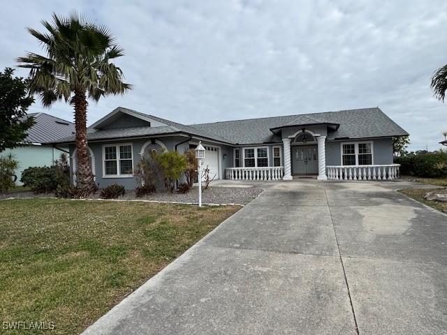 ranch-style house featuring an attached garage, a front lawn, concrete driveway, and stucco siding