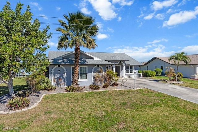 view of front facade featuring concrete driveway, a front yard, and stucco siding