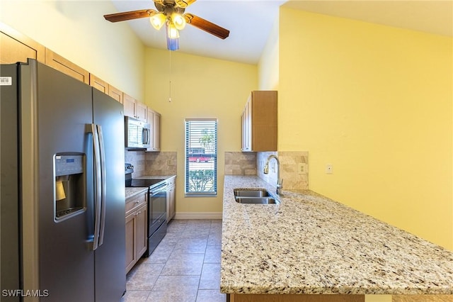 kitchen featuring light stone counters, stainless steel appliances, decorative backsplash, light tile patterned flooring, and a sink