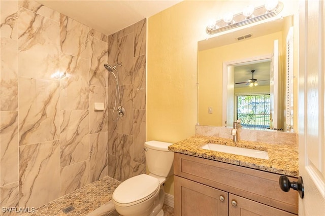 full bathroom featuring toilet, tiled shower, vanity, and visible vents